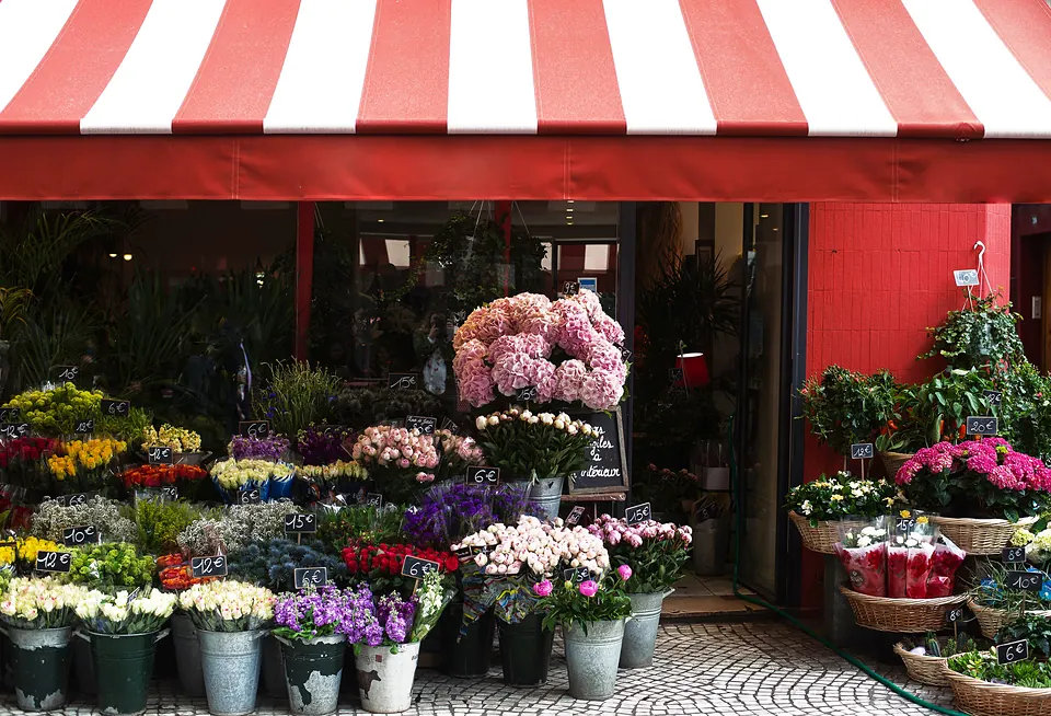 A flower shop with a red and white striped awning