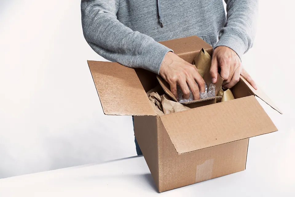 Someone packing an order into a cardboard box